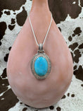 Bild in Galerie-Betrachter laden, Turquoise Pendant Enhancer hanging on a silver chain on a brown bottle and cowhide background