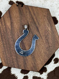 Load image into Gallery viewer, back side of Turquoise and Silver Horseshoe pendant laying on wood block