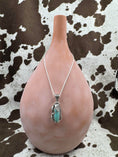 Bild in Galerie-Betrachter laden, Turquoise Leaf Pendant on silver chain hanging on brown bottle with cowhide background