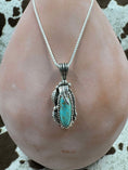 Bild in Galerie-Betrachter laden, Turquoise Leaf Pendant on silver chain hanging on brown bottle with cowhide background