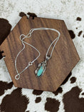 Bild in Galerie-Betrachter laden, Turquoise Leaf Pendant on silver chain hanging on brown block with cowhide background