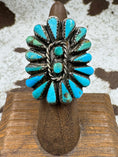 Load image into Gallery viewer, turquoise flower ring on wood stand with cowhide background