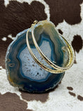 Bild in Galerie-Betrachter laden, Gold hoop earrings hanging from blue rock with cowhide background