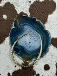 Bild in Galerie-Betrachter laden, Gold hoop earring laying open on blue rock with cowhide background