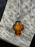 Load image into Gallery viewer, Floral Bouquet Amber Cross Set in Sterling Silver laying on moose antler piece