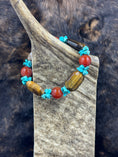 Load image into Gallery viewer, Unique Carnelian, Turquoise and Tiger Eye Bracelet on moose antler piece with dark fur background