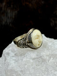 Load image into Gallery viewer, Bali Bone Ring "Face of the Moon" on white rock with dark background