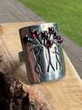 Load image into Gallery viewer, Garnet Adam and Eve Ring on wood block with grass in the background