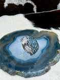 Load image into Gallery viewer, Single Blue Topaz and Sterling SIlver Earrings on blue rock with cowhide background