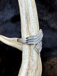 Load image into Gallery viewer, side view of Goregous Genuine Diamond Swirl Ring on moose antler with fur background