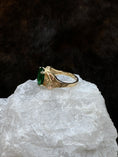 Load image into Gallery viewer, Side view of Black Hills Gold Coleman 10K Lab Created Emerald on white rock with fur background
