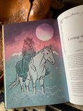 Load image into Gallery viewer, Book page with woman and horse and a saddle in the background
