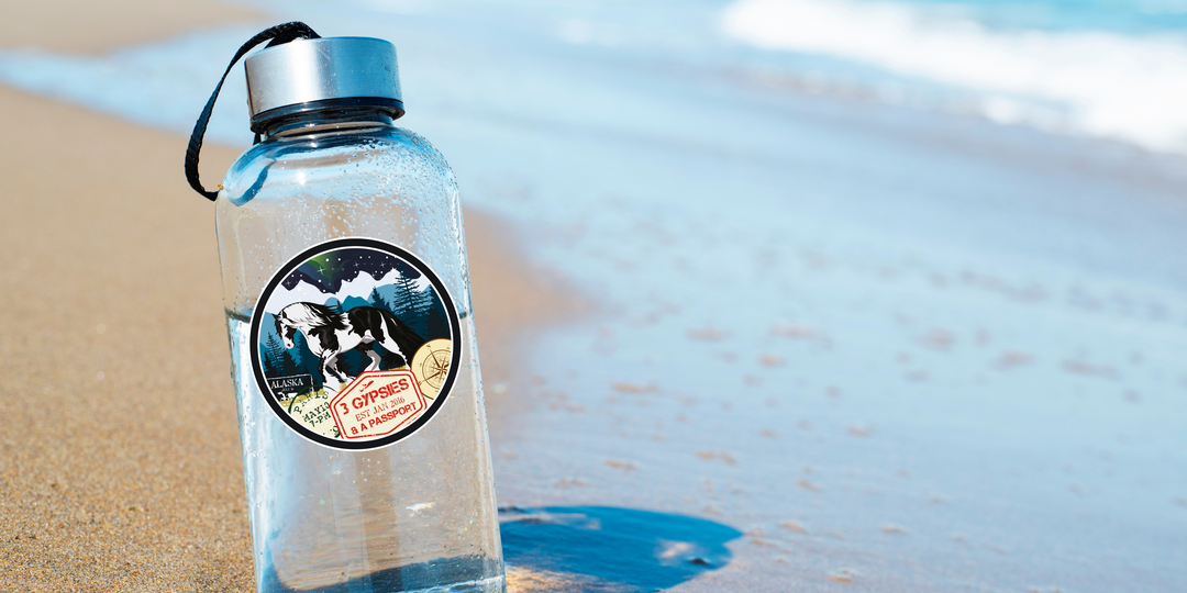 Water bottle on the beach with a 3 Gypsies Sticker on it