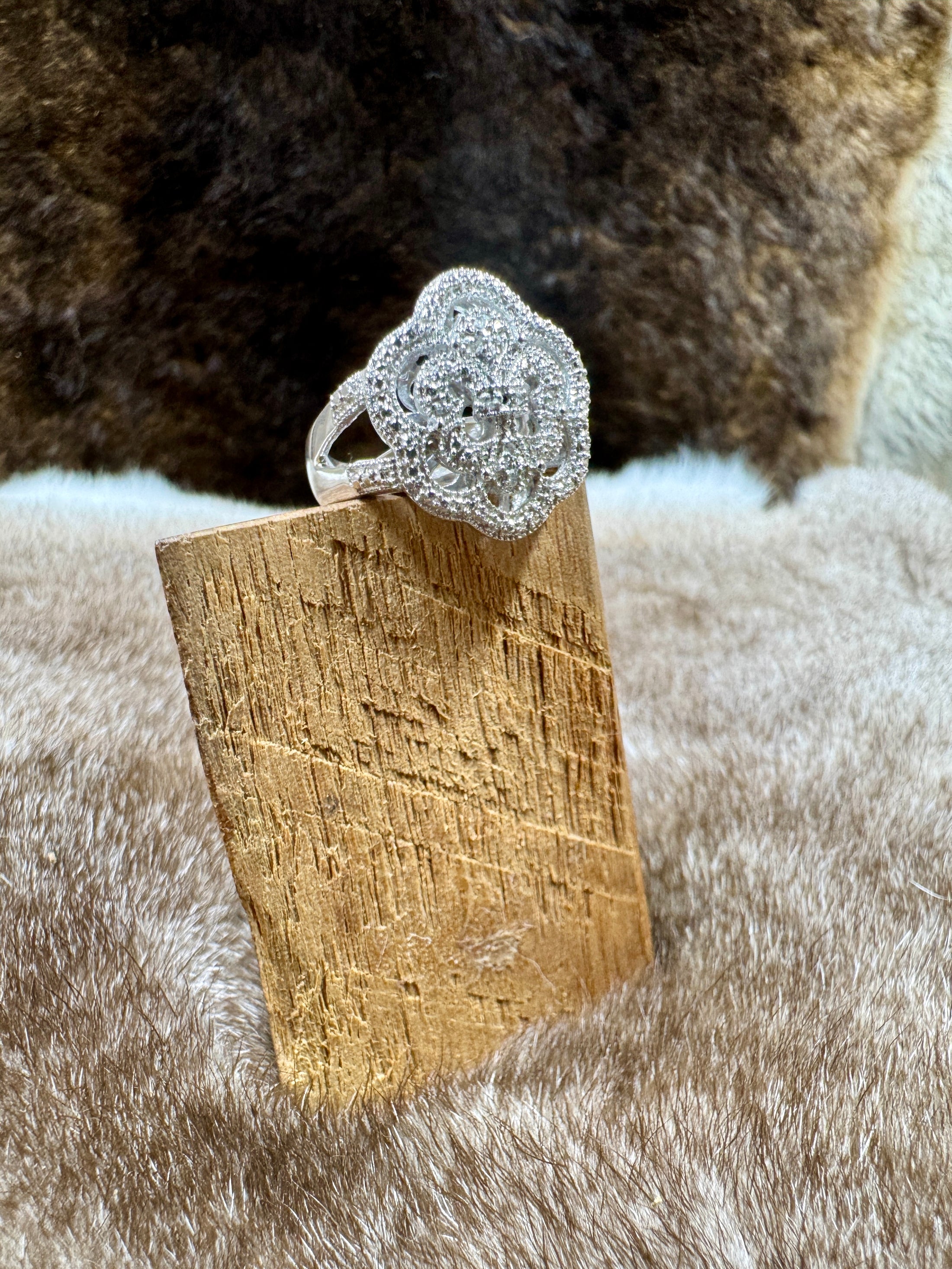 Silver ring on a wooden block with a fur background