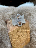 Load image into Gallery viewer, Silver hearts ring on a wooden block with a fur background
