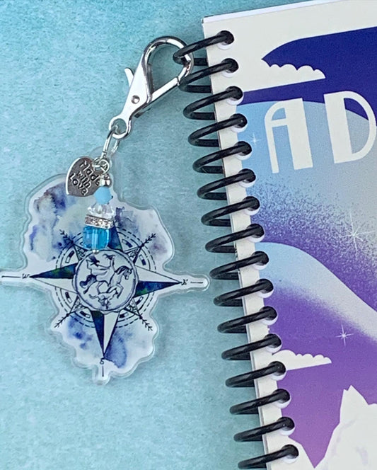 Compass planner charm showing horse, raven and dog