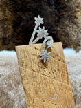 Load image into Gallery viewer, Silver star-shaped ring on a wooden block with a fur background
