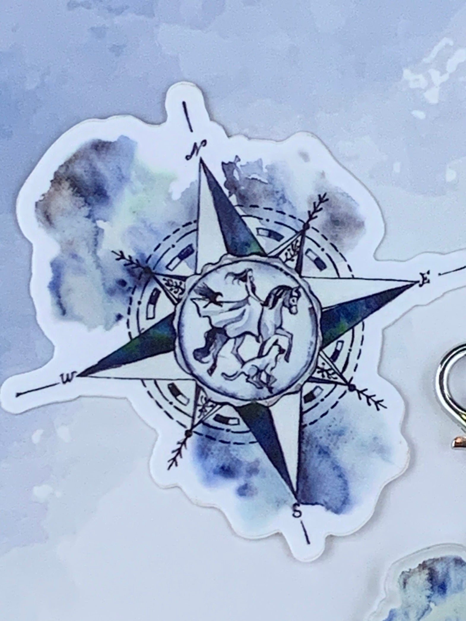 Compass sticker with horse dog and raven in the middle