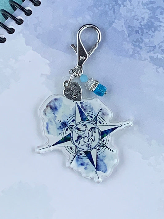 Compass planner charm showing horse, raven and dog