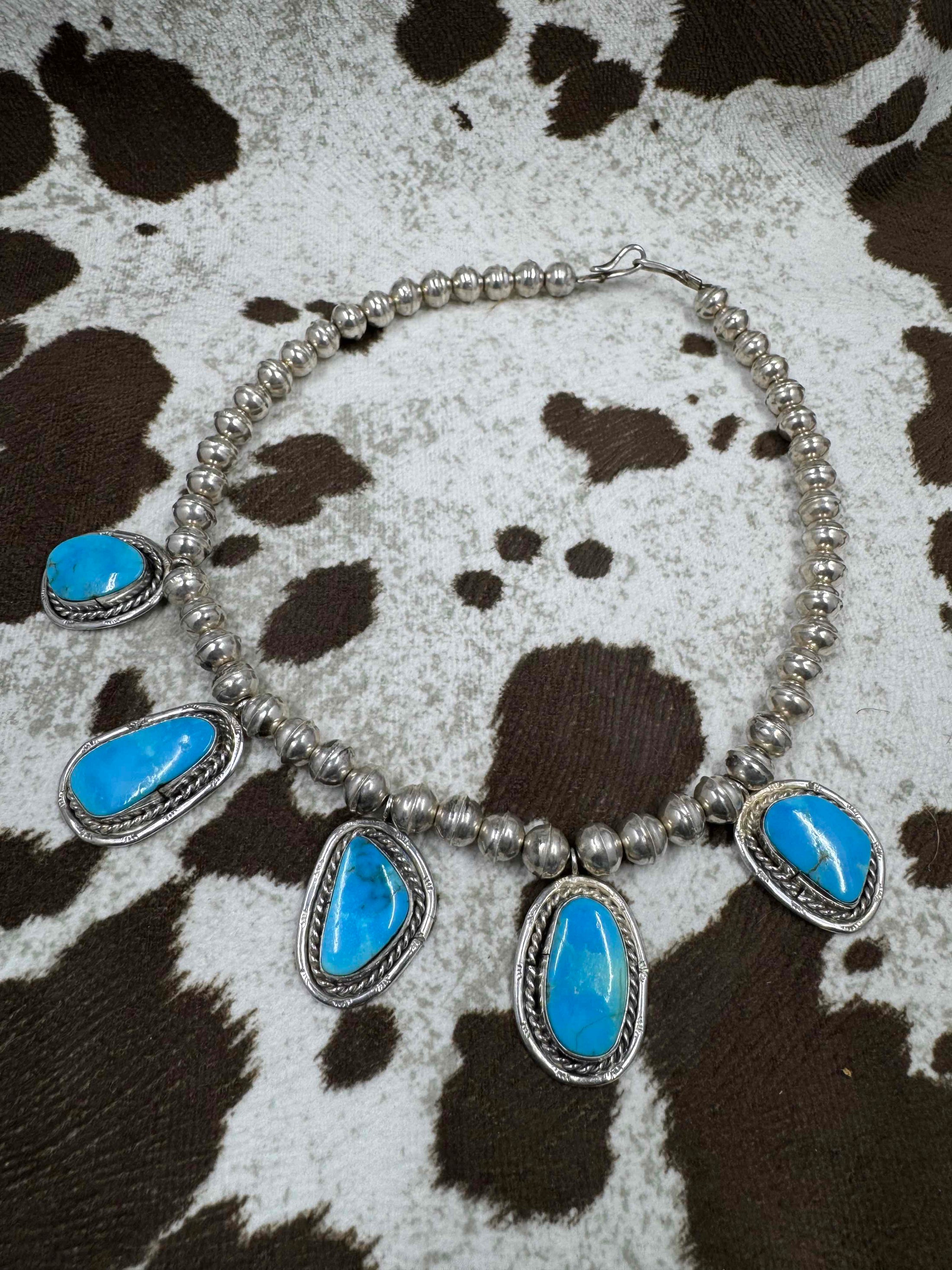 Vintage 5 Stone Silver and Turquoise Necklace laying on cowhide 