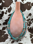 Load image into Gallery viewer, Sterling Silver and Turquoise Chip Chunk Bead Necklace on brown bottle with cowhide background
