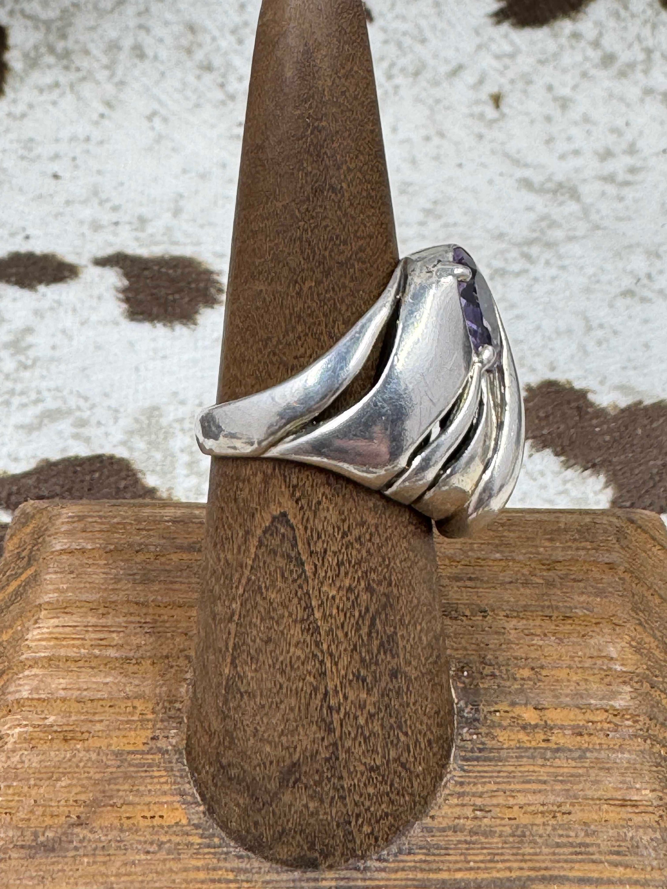 Side view Vintage Kabana Amethyst Dome Ring on brown stand with cowhide background