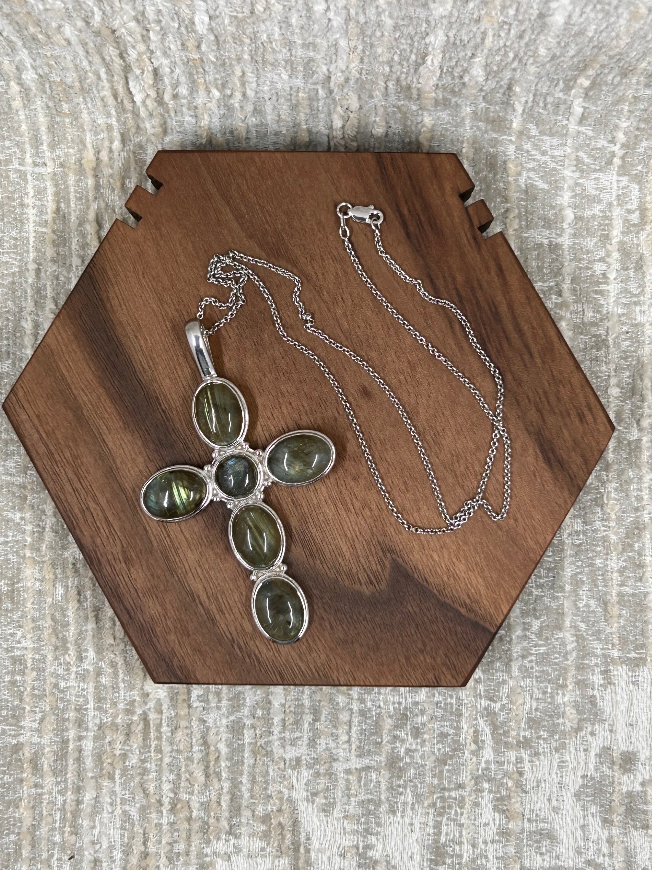 Labradorite Cross Pendant with Sterling Silver Chain on wood block with white background