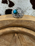 Load image into Gallery viewer, Chrysocolla Stone Cabochon ring sitting on a wood block with cowhide background
