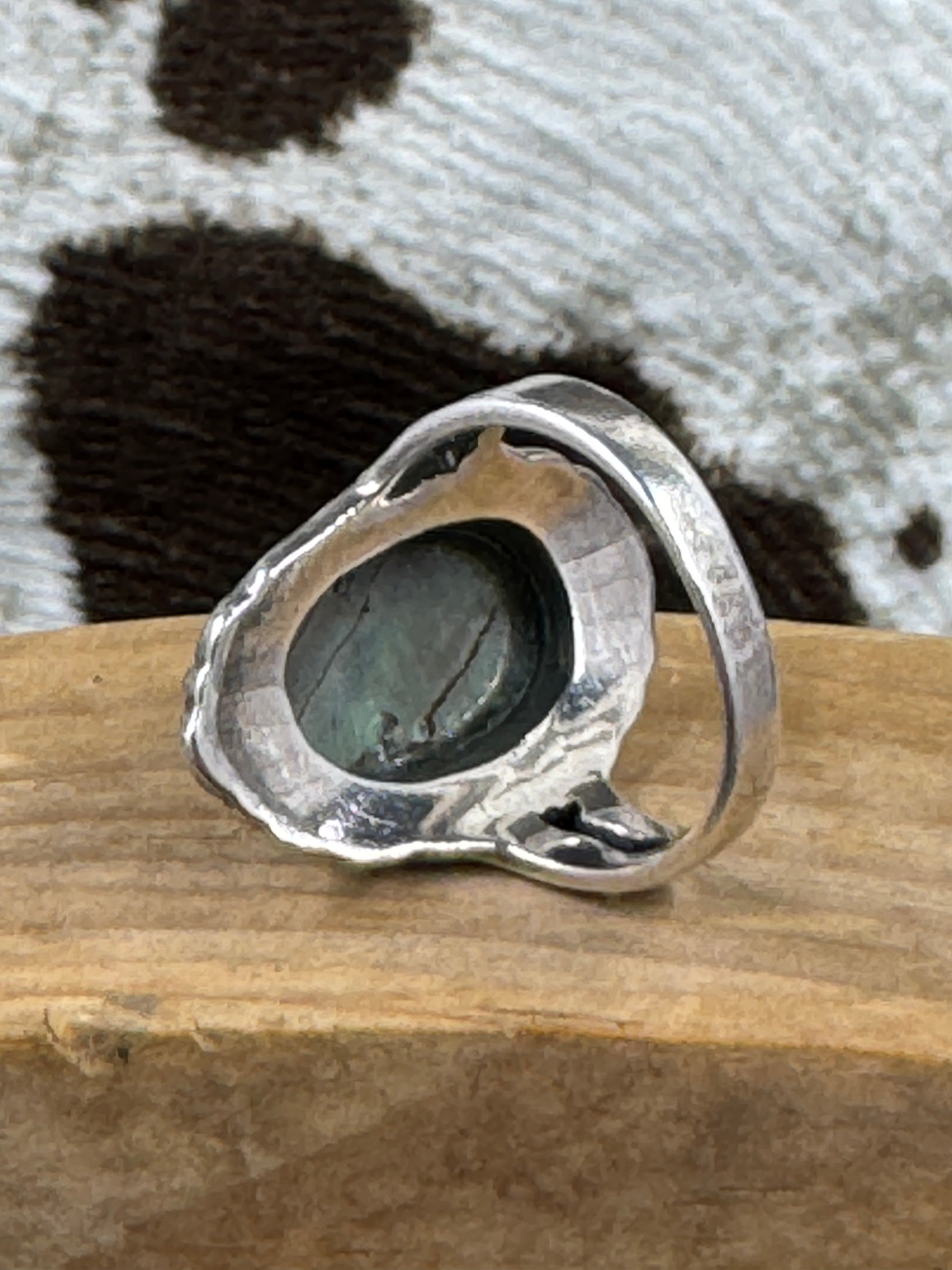 underside of Abalone and Marcasite Sterling SIlver Ring on wood block with cowhide background