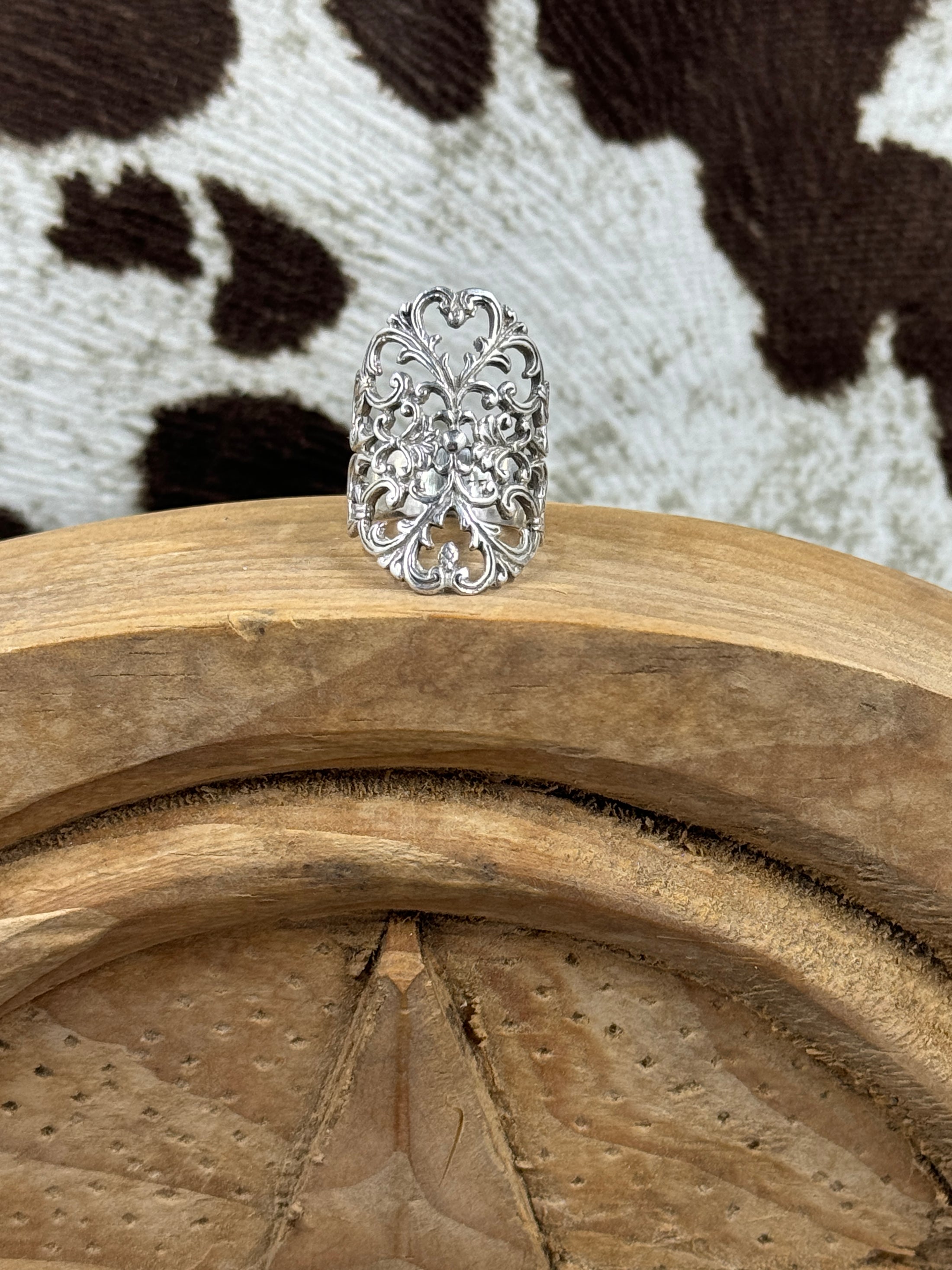 Sterling Silver Ring on wood block with cowhide background