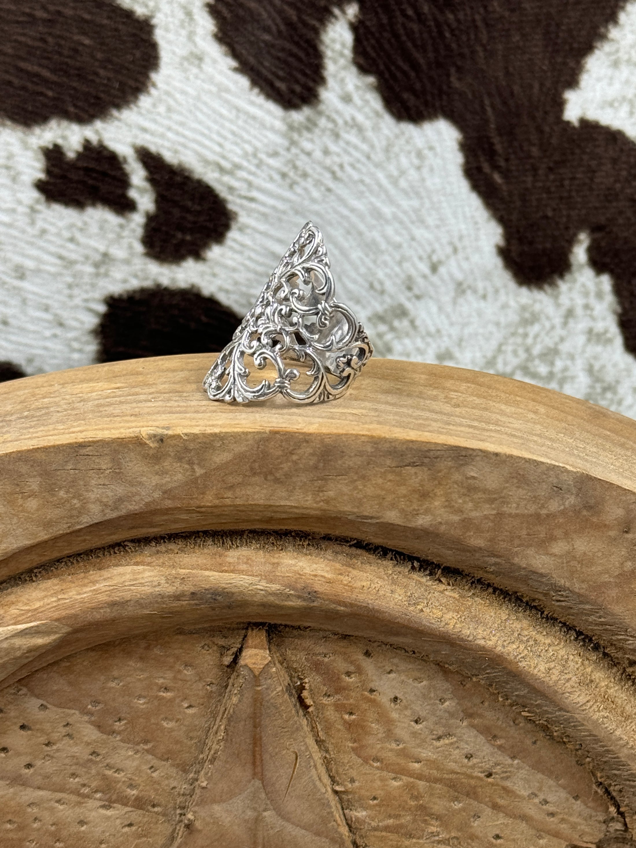 Side view Sterling Silver Ring on wood block with cowhide background