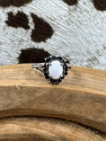 Load image into Gallery viewer, Australian White Opal Halo Sapphire Ring on wood block with cowhide background
