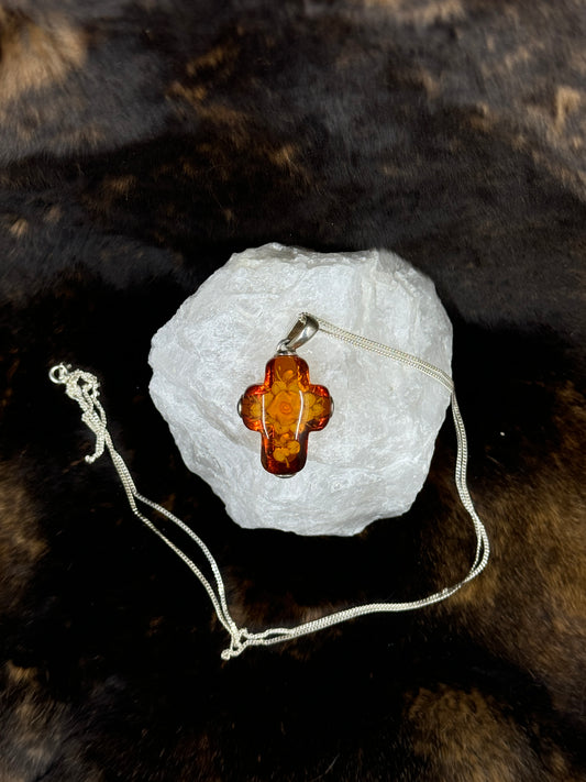 Floral Bouquet Amber Cross Set in Sterling Silver on white rock with dark fur background