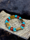 Load image into Gallery viewer, Unique Carnelian, Turquoise and Tiger Eye Bracelet on moose antler piece on dark fur background
