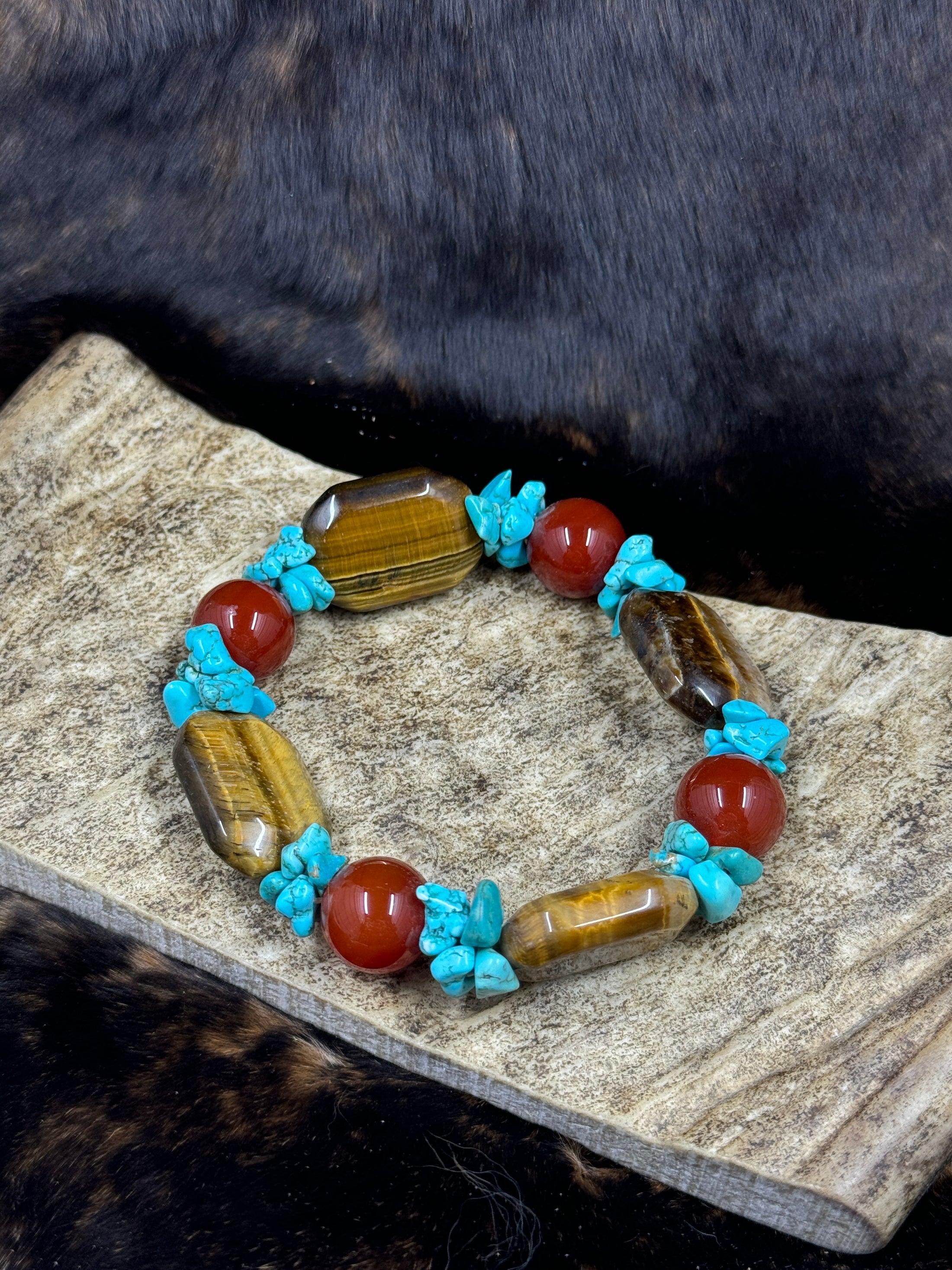 Unique Carnelian, Turquoise and Tiger Eye Bracelet on moose antler piece on dark fur background