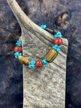 Load image into Gallery viewer, Unique Carnelian, Turquoise and Tiger Eye Bracelet on moose antler piece with dark fur background
