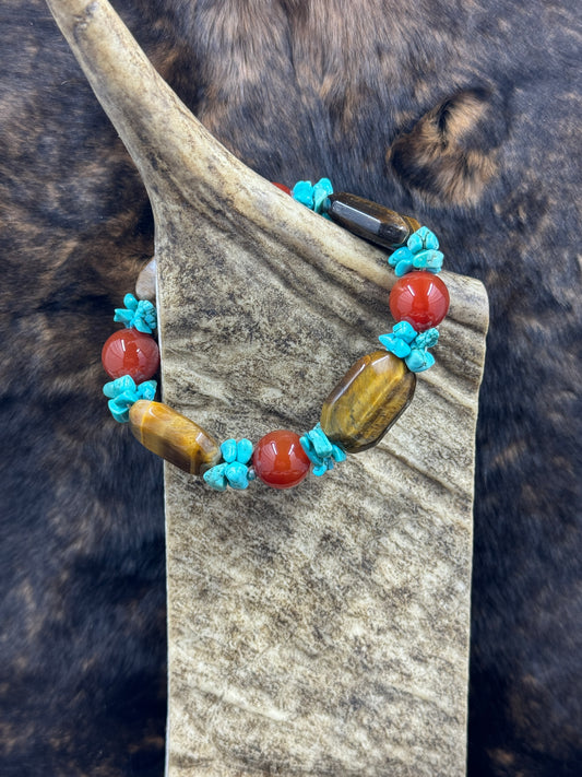 Unique Carnelian, Turquoise and Tiger Eye Bracelet on moose antler piece with dark fur background