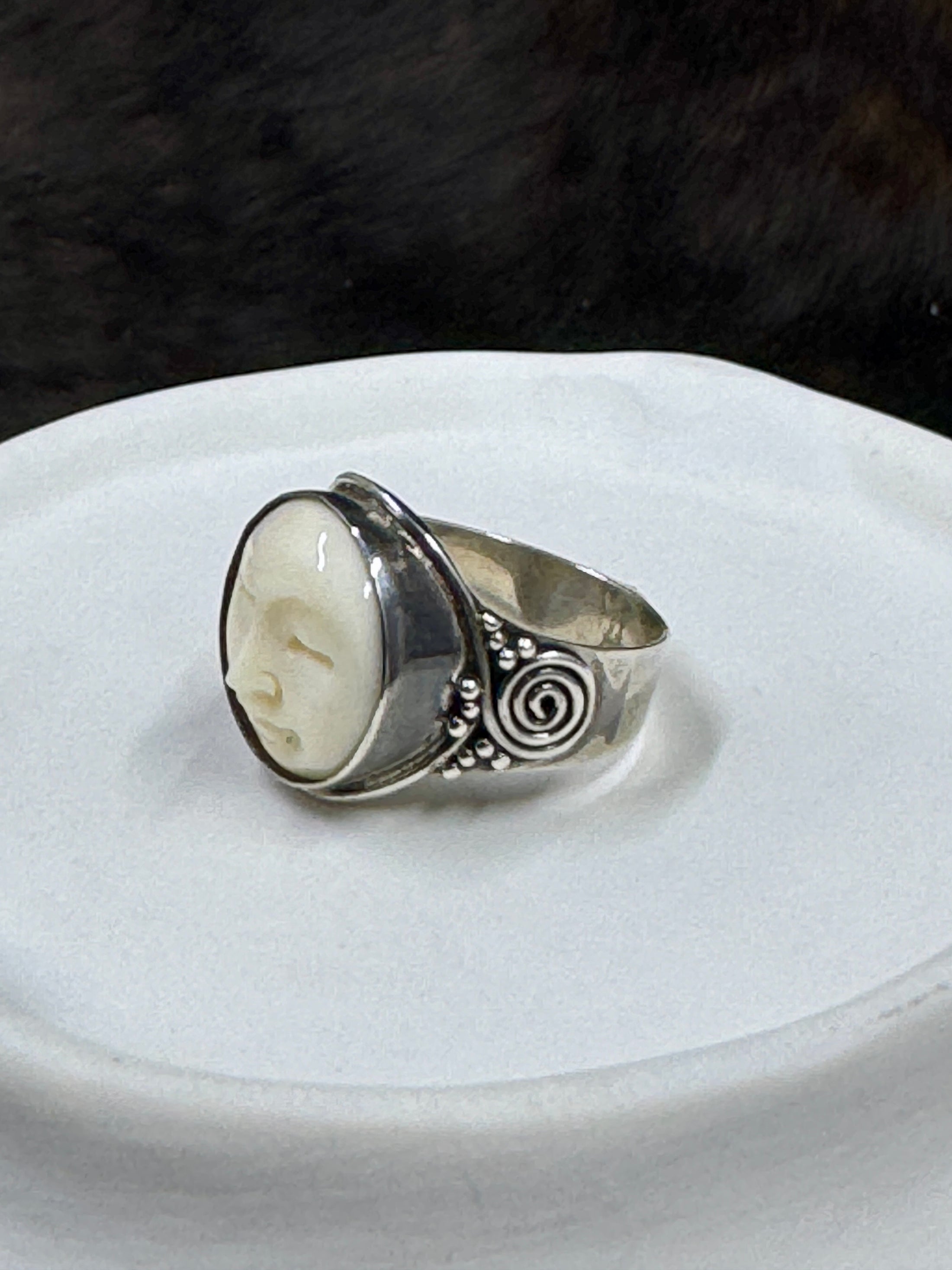 Bali Bone Ring "Face of the Moon" on white rock with dark background