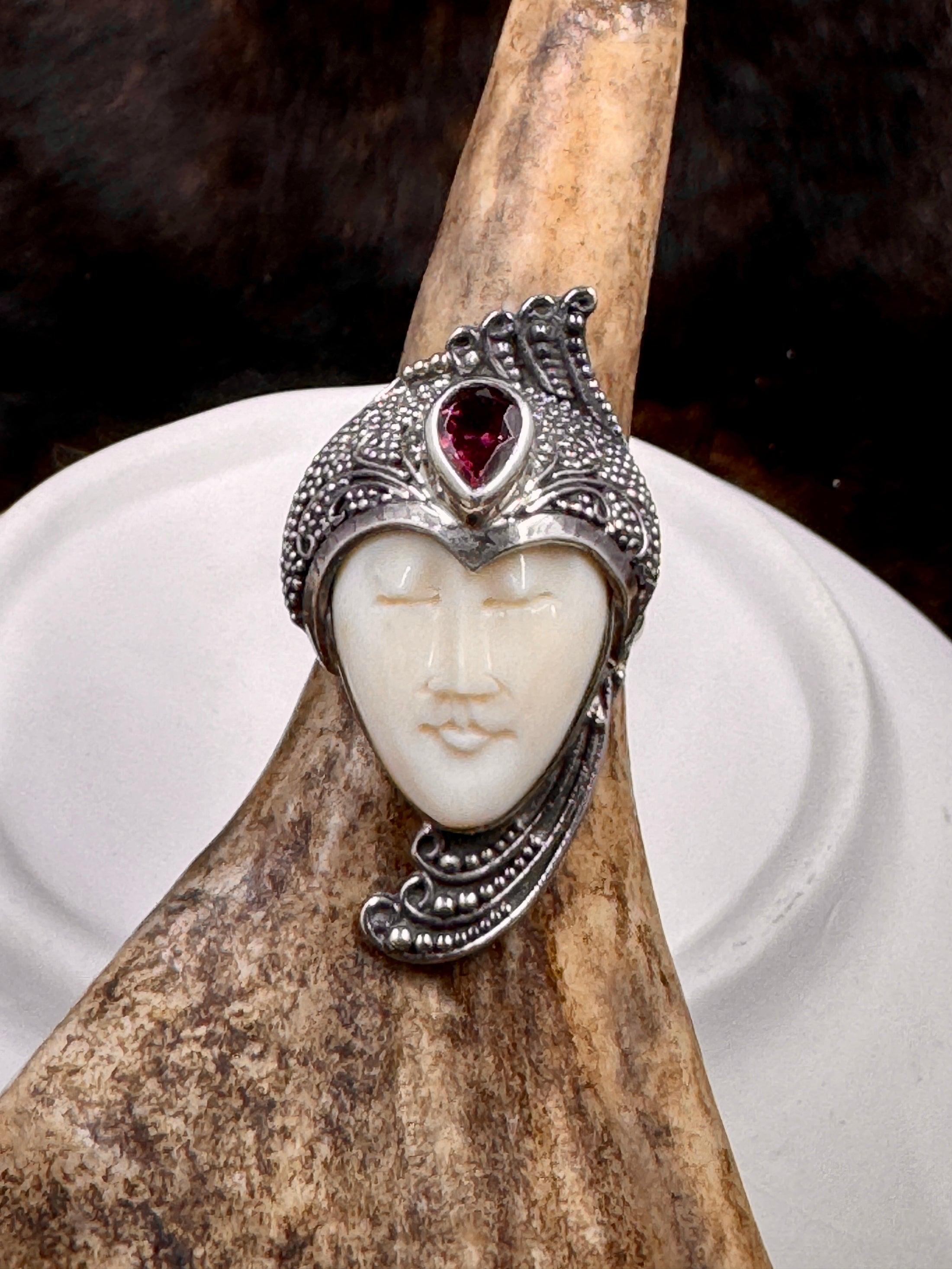 Bali Carved Bone Face Goddess Ring with Amethyst Colored Stone on moose antler with white and brown background