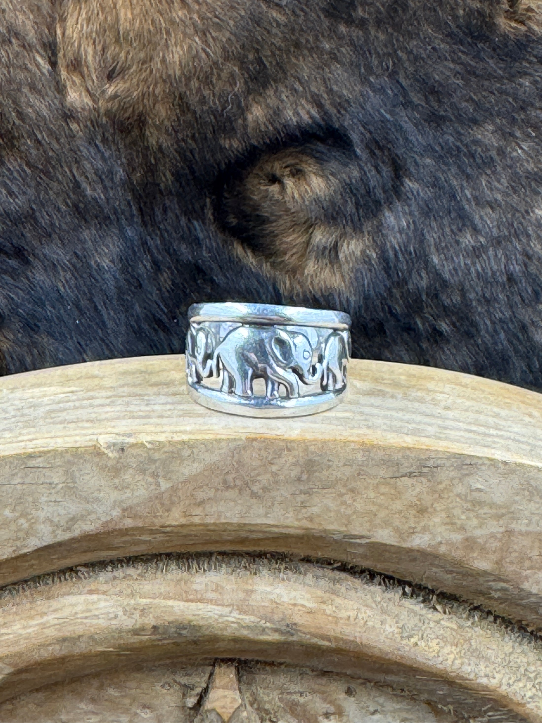 Vintage Sterling Silver Elephant with Babies Ring on wood block with dark fur background