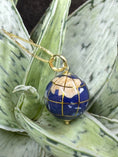 Bild in Galerie-Betrachter laden, Vintage 14K World Glob Inlay Charm Pendant by Michael Anthony sitting on green plant
