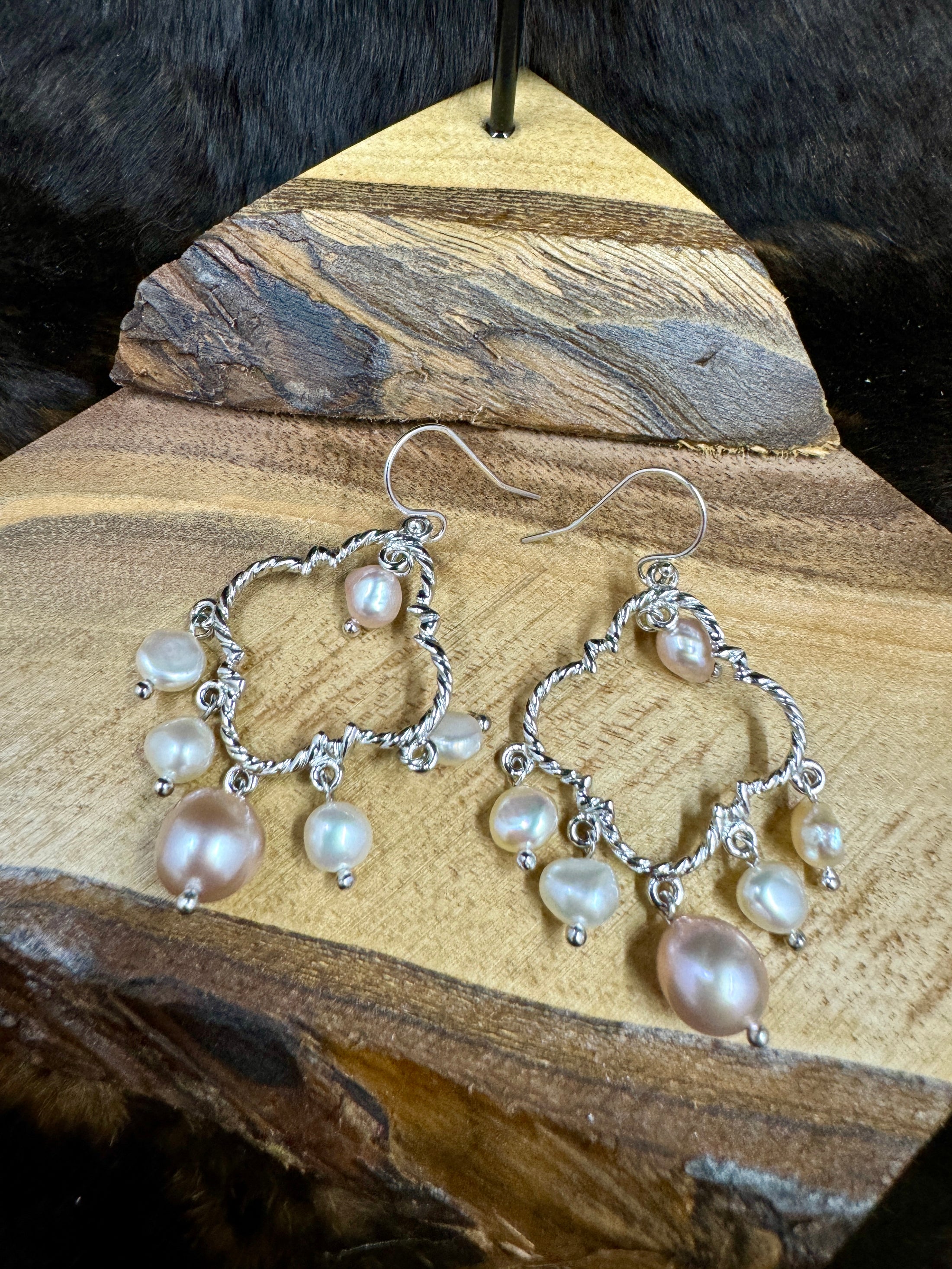 Pearl Chandelier Earrings on wood block with dark fur background