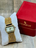 Load image into Gallery viewer, Peugeut Gold and Crystal Ladies Watch on wood back ground with red box
