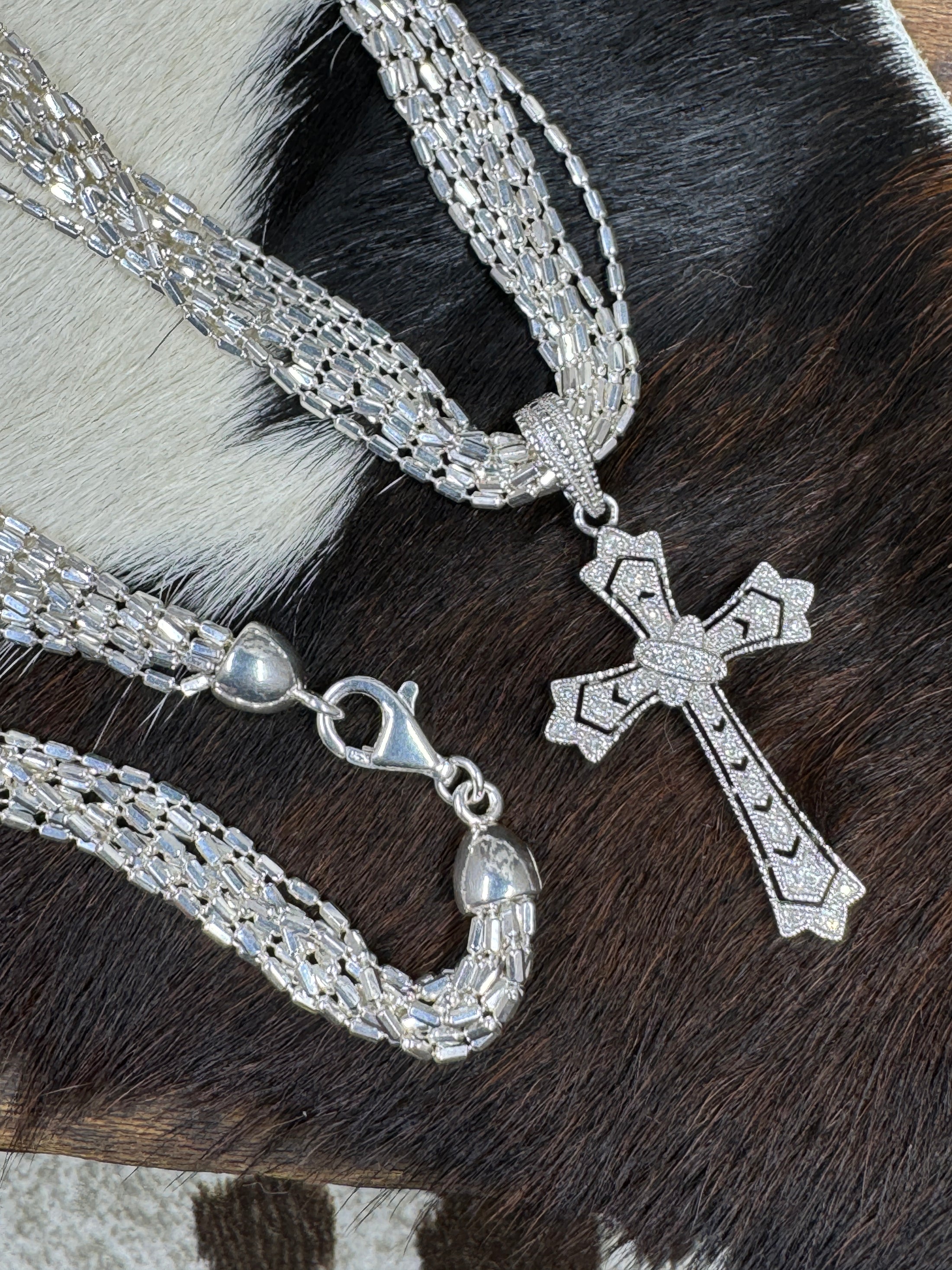 Diamond Chip and Sterling Silver Cross Pendant by Barbara Bixbie, with silver chain on cowhide background