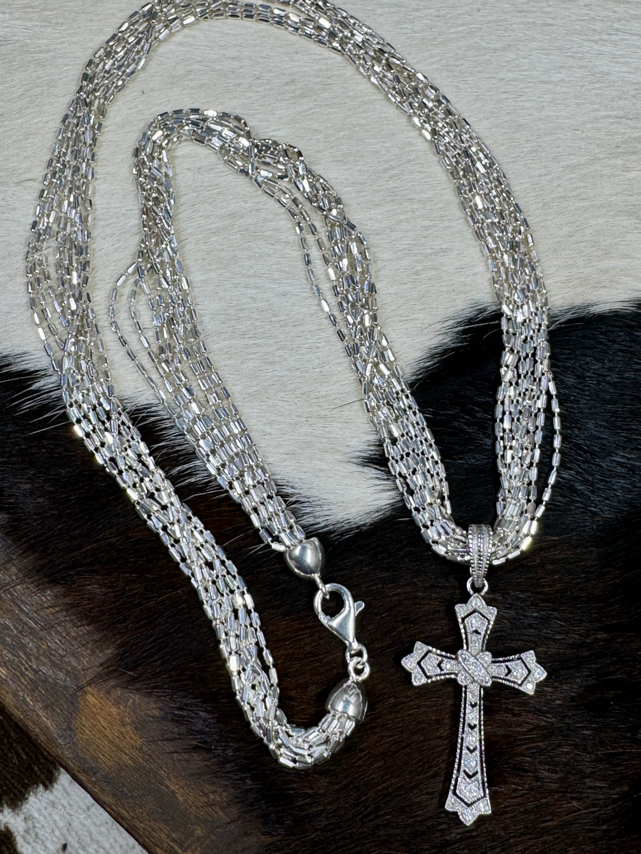 Diamond Chip and Sterling Silver Cross Pendant by Barbara Bixbie with Silver Chain on cowhide background