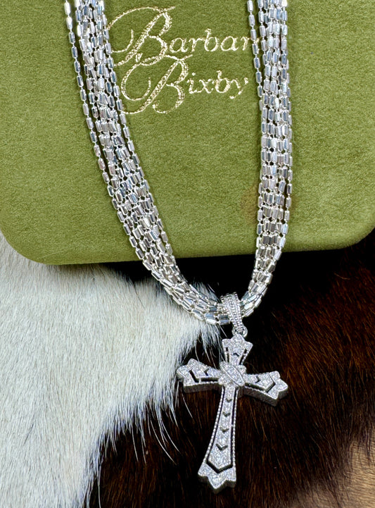 Diamond Chip and Sterling Silver Cross Pendant by Barbara Bixbie with Silver Chain on cowhide background and with green box that says Barbara Bixby