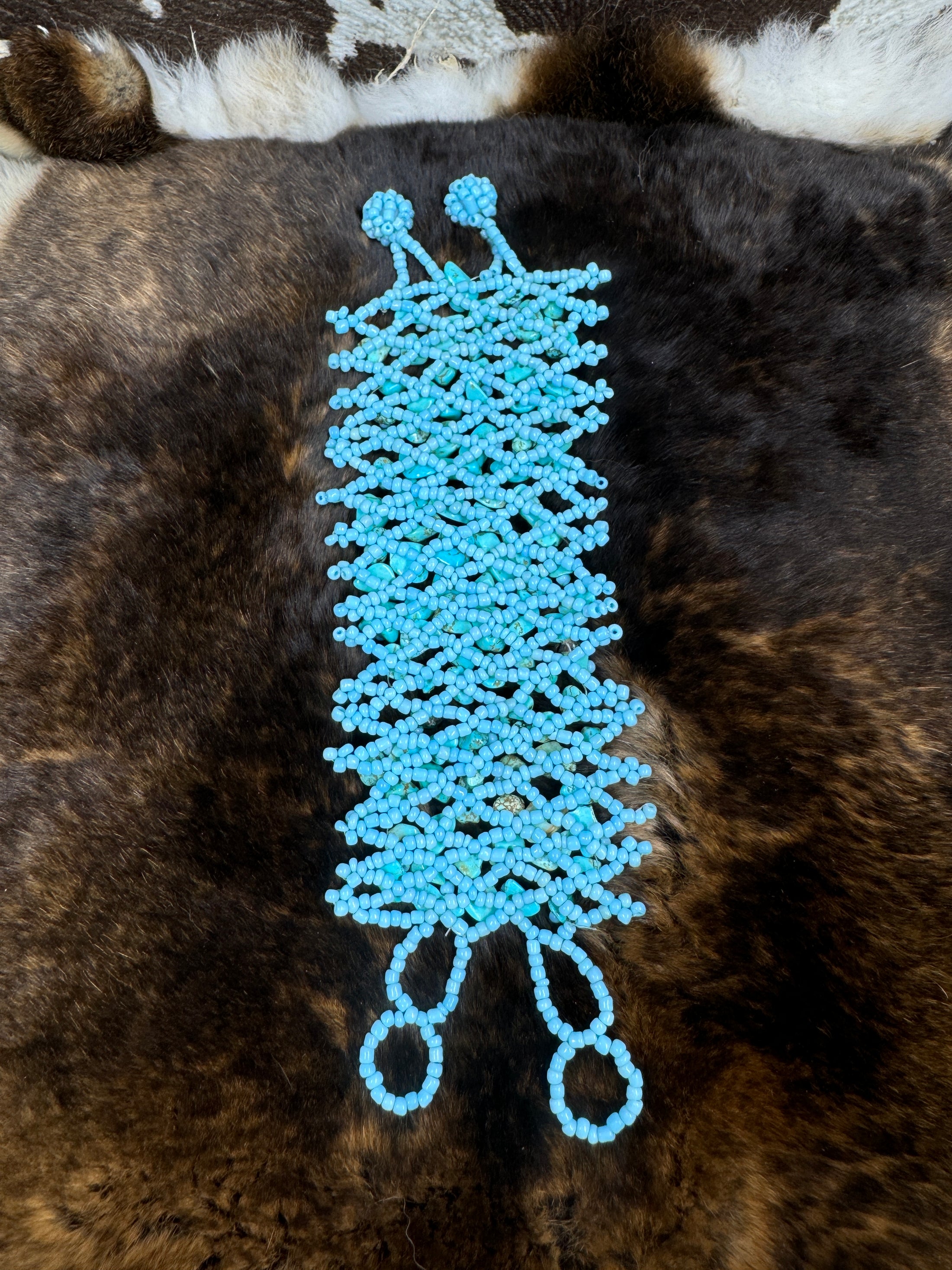 Handcrafted Turqoise Beaded Bracelet laying flat on fur background