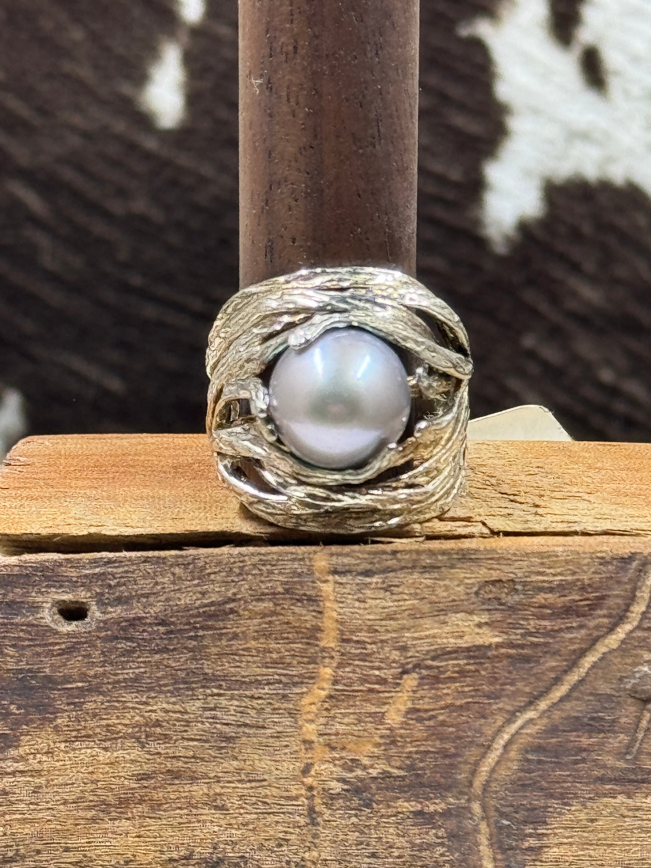 Sterling Silver and Cultured Freshwater Pearl Ring on brown stand with cowhide background