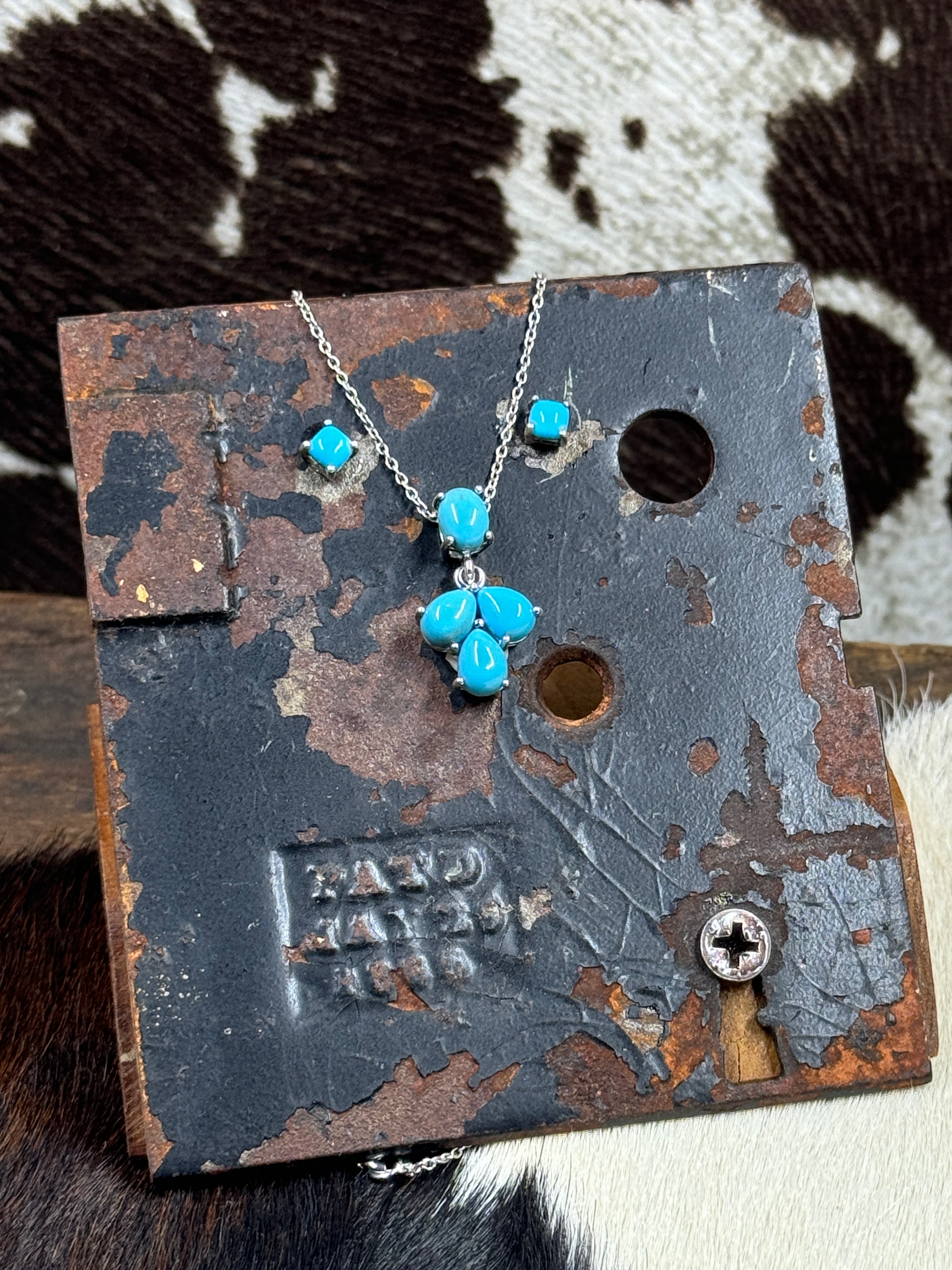 Vintage Sterling Silver and Turquoise Necklace and Earrings on black stand with cowhide background