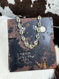 Bild in Galerie-Betrachter laden, Silver Stainless Steel and Peridot Gem Bracelet on metal stand with cowhide background
